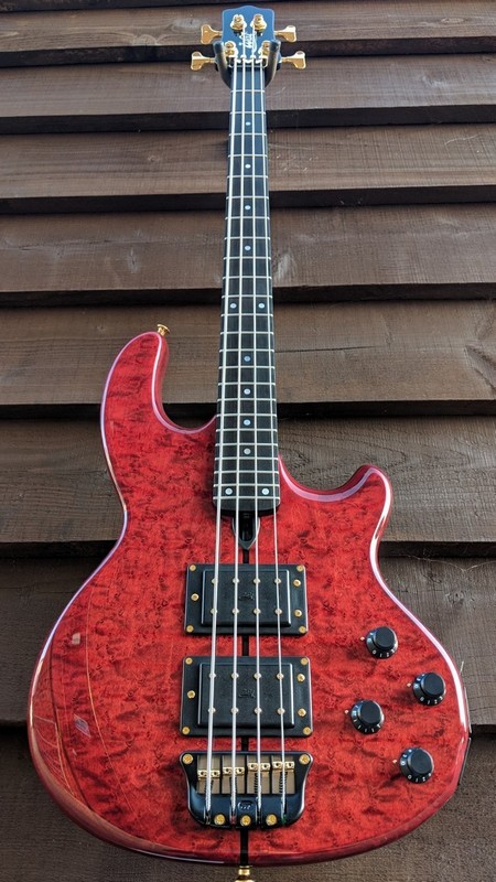 Mk2 with birdseye maple facings with ebony centre stripe, a gloss trans. red body finish, gloss black neck finish, an ebony fingerboard and gold hardware.